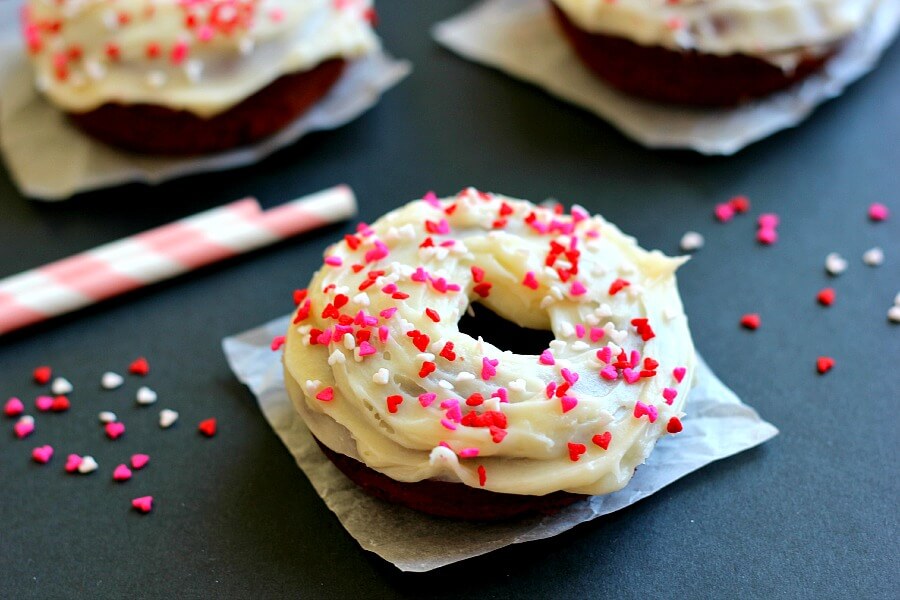 A red velvet cake donut on a square of parchment paper. 