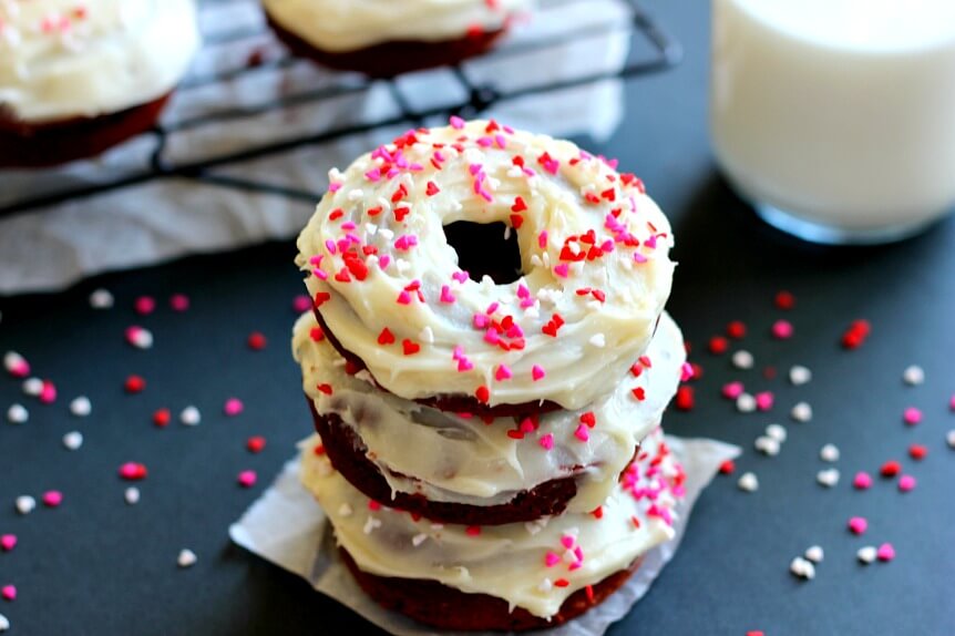 A stack of three frosted red velvet donuts.