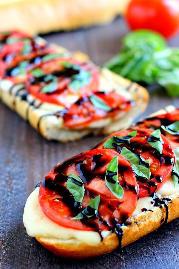 This Toasted Caprese Garlic Bread is made with hints of garlic and topped with ripe tomatoes, fresh basil, and creamy mozzarella cheese! #garlicbread #caprese #capreserecipe #capresebread #capresegarlicbread #garlicbreadrecipe