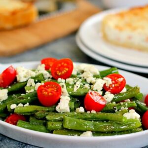 This Roasted Garlic Green Bean Salad is filled with fresh beans, ripe tomatoes and feta cheese, combined with a light garlic and lemon dressing!