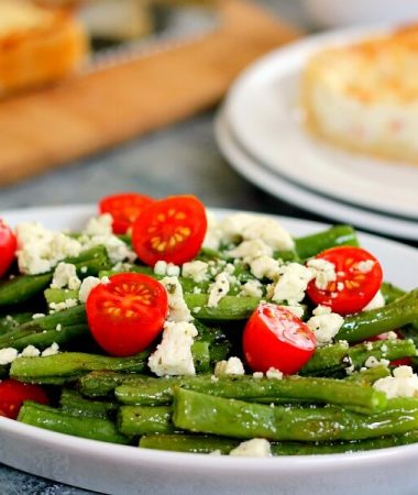 This Roasted Garlic Green Bean Salad is filled with fresh beans, ripe tomatoes and feta cheese, combined with a light garlic and lemon dressing!