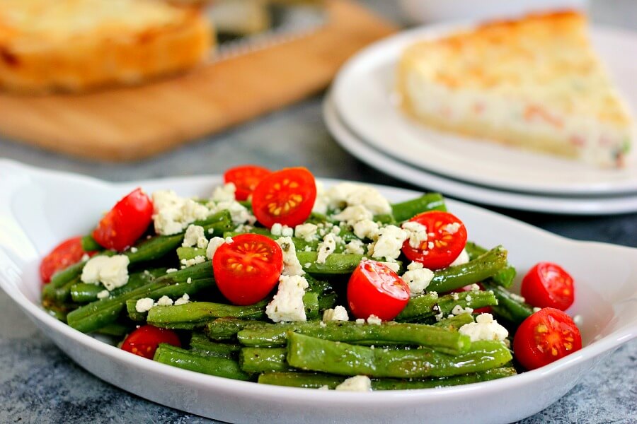 Roasted Garlic Green Beans are filled with fresh beans, ripe tomatoes and feta cheese, combined with a light garlic and lemon dressing! #greenbeans #greenbeanrecipe #roastedgreenbeans #vegetables #roastedvegetables #sidedish #easysidedish