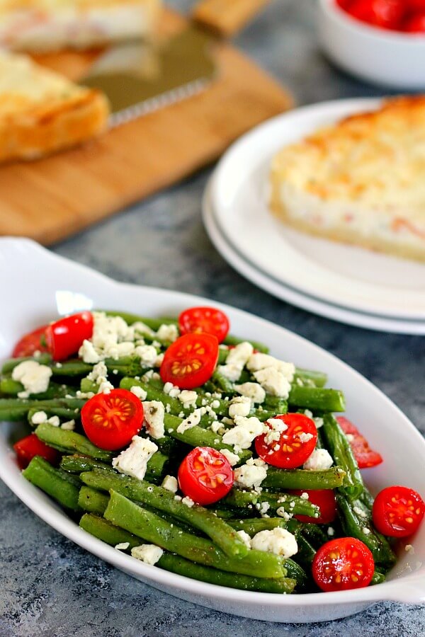 Roasted Garlic Green Beans are filled with fresh beans, ripe tomatoes and feta cheese, combined with a light garlic and lemon dressing! #greenbeans #greenbeanrecipe #roastedgreenbeans #vegetables #roastedvegetables #sidedish #easysidedish