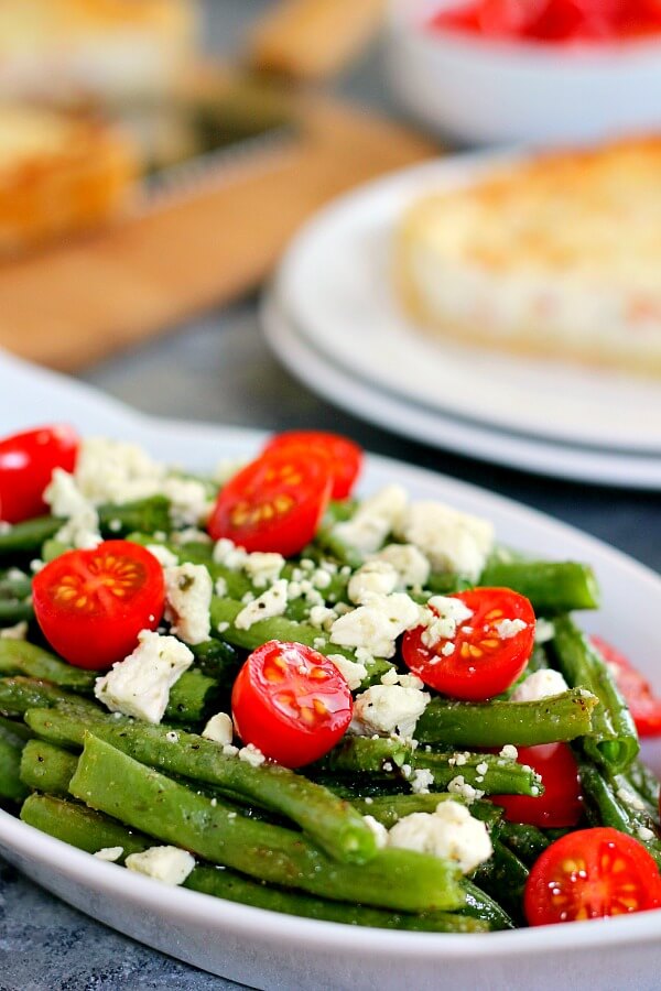 Roasted Garlic Green Beans are filled with fresh beans, ripe tomatoes and feta cheese, combined with a light garlic and lemon dressing! #greenbeans #greenbeanrecipe #roastedgreenbeans #vegetables #roastedvegetables #sidedish #easysidedish