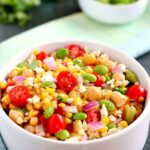 Jam-packed with corn, edamame, chickpeas, and tomatoes, this Corn, Edamame, and Chickpea Salad is full of flavor and makes the perfect light lunch or dinner. By adding a touch of feta cheese, red onion, cilantro, lime juice, and a white balsamic dressing, the ingredients blend together to make a zesty dish!