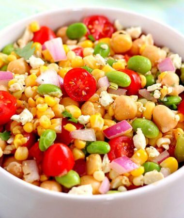 Jam-packed with corn, edamame, chickpeas, and tomatoes, this Corn, Edamame, and Chickpea Salad is full of flavor and makes the perfect light lunch or dinner. By adding a touch of feta cheese, red onion, cilantro, lime juice, and a white balsamic dressing, the ingredients blend together to make a zesty dish!