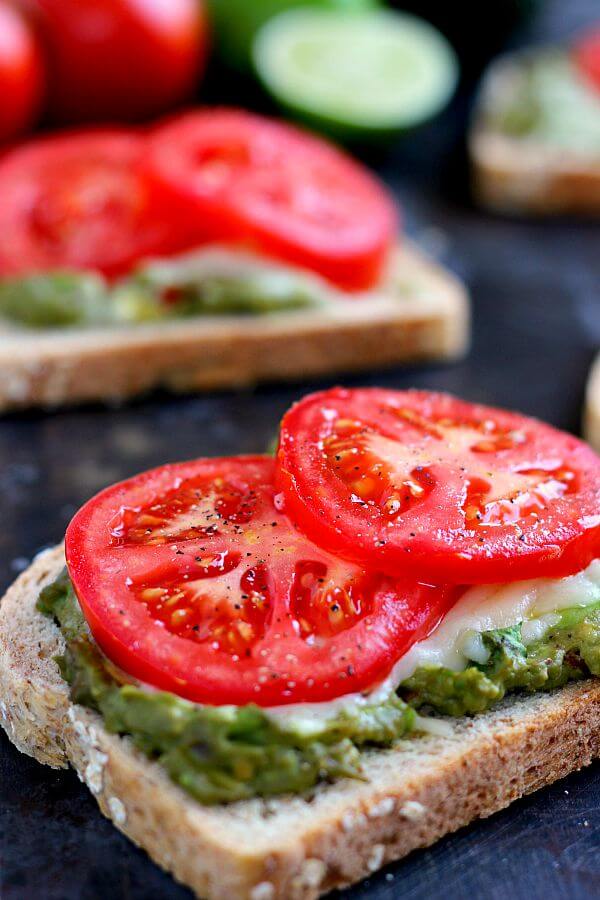 This Cheesy Guacamole Toast is loaded with creamy guacamole, mozzarella cheese, and fresh tomatoes. Full of flavor and healthy ingredients, this toast makes the perfect breakfast or mid-morning snack!