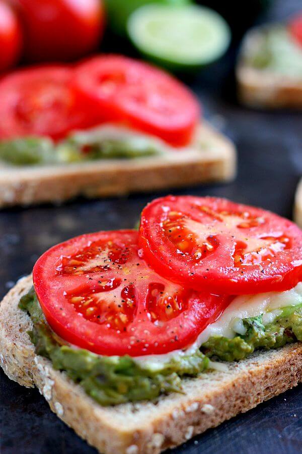 This Cheesy Guacamole Toast is loaded with creamy guacamole, mozzarella cheese, and fresh tomatoes. Full of flavor and healthy ingredients, this toast makes the perfect breakfast or mid-morning snack!