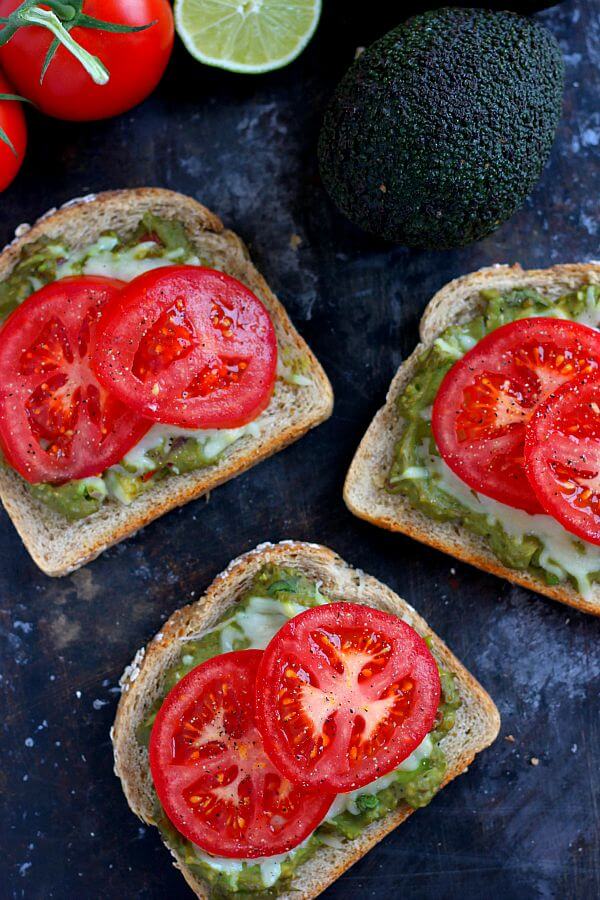 This Cheesy Guacamole Toast is loaded with creamy guacamole, mozzarella cheese, and fresh tomatoes. Full of flavor and healthy ingredients, this toast makes the perfect breakfast or mid-morning snack!
