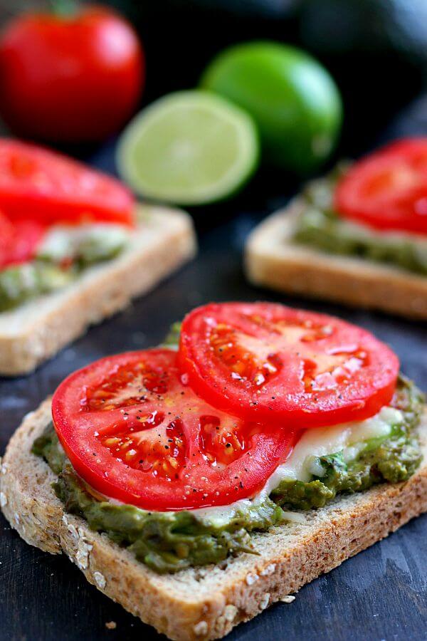 This Cheesy Guacamole Toast is loaded with creamy guacamole, mozzarella cheese, and fresh tomatoes. Full of flavor and healthy ingredients, this toast makes the perfect breakfast or mid-morning snack!