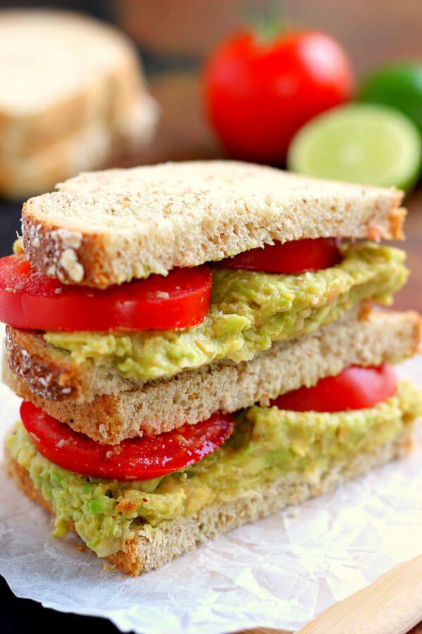 A smashed chickpea avocado sandwich cut in half and stacked on itself. 