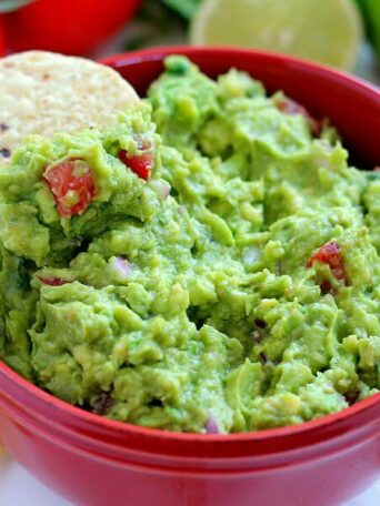 Filled with ripe avocados, fresh tomatoes, red onions, and spices, this Zesty Guacamole is jam-packed with flavor and ready to eat in just five minutes. It makes the perfect dip for chips, toppings for tacos and burritos, and spreads for sandwiches!