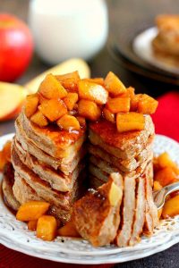 a fork taking a bite out of apple pancakes