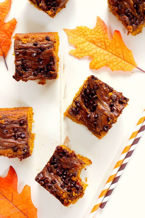 These Chocolate-Swirled Pumpkin Bars are soft, moist, and bursting with flavor. The pumpkin cake is filled with hints of cinnamon and spices and swirled with a chocolate cream cheese mixture! #pumpkin #pumpkinbars #pumpkinbarrecipe #pumpkincake #pumpkincakerecipe #creamcheesefrosting #chocolatefrosting #chocolatecreamcheesefrosting #pumpkinrecipe #falldessert #fallrecipe #falldessertrecipe