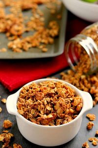 This Apple Pie Granola recipe is jam-packed with hearty oats, walnuts, and cozy fall spices. It makes for a great snack or healthy breakfast and tastes like apple pie, plus it's gluten free! #granola #apples #applegranola #applepie #fallrecipe #fallbreakfast #fallsnack #applesnack #snack #breakfast #glutenfreebreakfast #glutenfreegranola