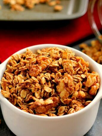 apple pie granola in a dish in front of a baking pan