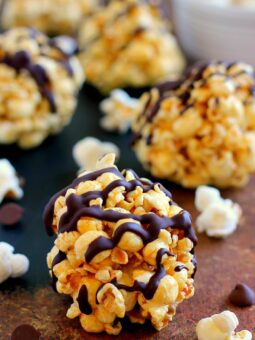 These Caramel Popcorn Balls combine fresh popcorn, caramel sauce, marshmallows, and dark chocolate. This easy snack is perfect to munch on when you need to satisfy those sweet and salty cravings!