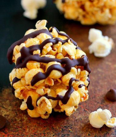 These Caramel Popcorn Balls combine fresh popcorn, caramel sauce, marshmallows, and dark chocolate. This easy snack is perfect to munch on when you need to satisfy those sweet and salty cravings!