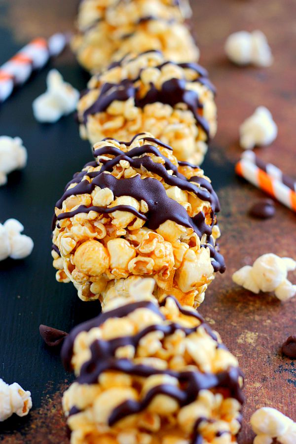 a row of homemade popcorn balls drizzled with chocolate 
