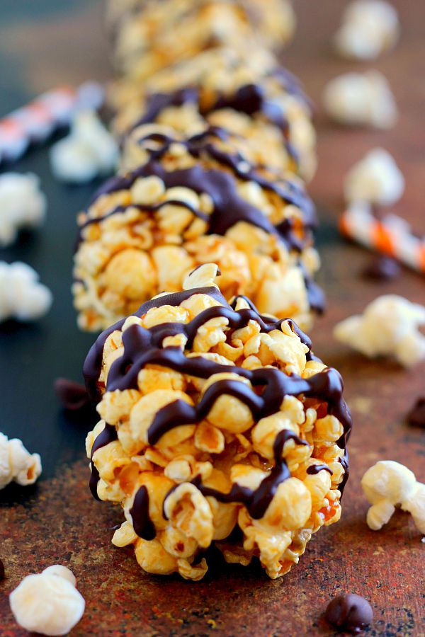 a row of homemade popcorn balls drizzled with chocolate 