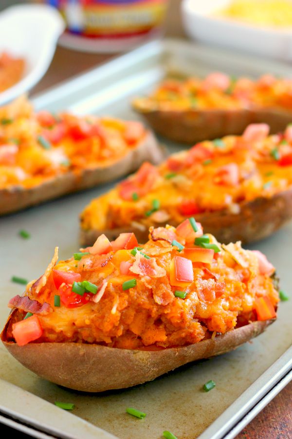 These Loaded Twice Baked Sweet Potatoes make the perfect side dish for any meal. The sweet potatoes are packed with with a brown sugar and cinnamon filling and then topped with cheese, crispy bacon, and sour cream. It's filled with flavor and the perfect fall dish for when you want something warm and comforting! #sweetpotatoes #sweetpotatorecipe #bakedsweetpotatoes #bakedsweetpotatorecipes #potatorecipes #sidedishes #fallrecipes