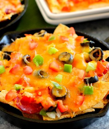 These Pizza Skillet Nachos are packed with two kinds of cheese, hearty pepperoni, black olives, tomatoes, and green peppers. Filled with classic pizza toppings, this is the perfect snack to munch on while relaxing on game day!