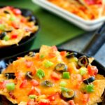 These Pizza Skillet Nachos are packed with two kinds of cheese, hearty pepperoni, black olives, tomatoes, and green peppers. Filled with classic pizza toppings, this is the perfect snack to munch on while relaxing on game day!