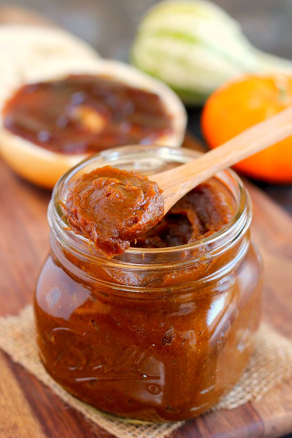 jar of pumpkin butter with wooden spoon resting on top 