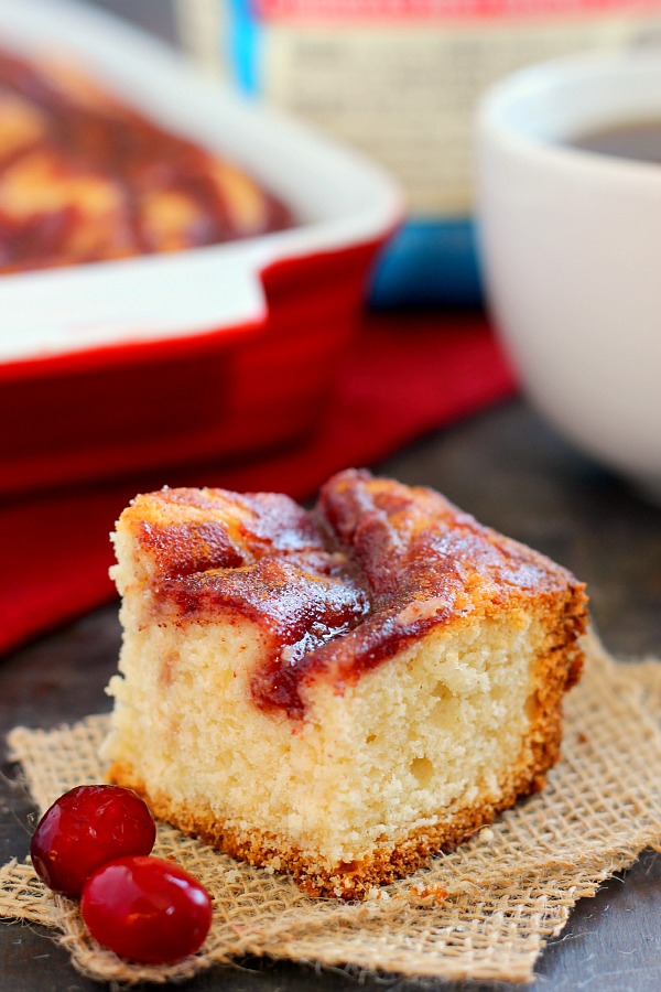 A slice of cranberry coffee cake on a square of burlap. 