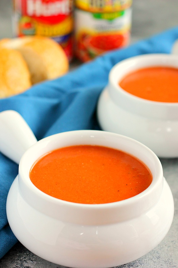 Two ramekins filled with creamy tomato basil soup.