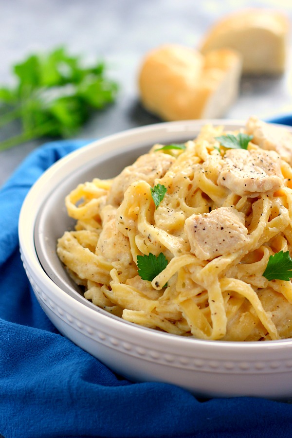 side view of chicken fettuccine alfredo garnished with fresh parsley