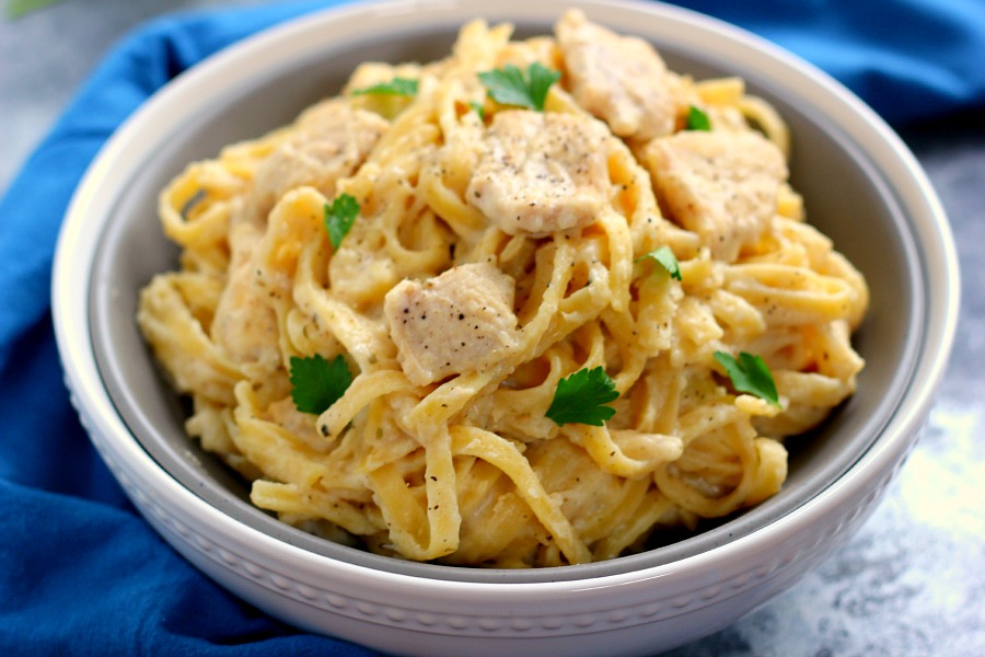 chicken fettuccine alfredo in a white and gray bowl