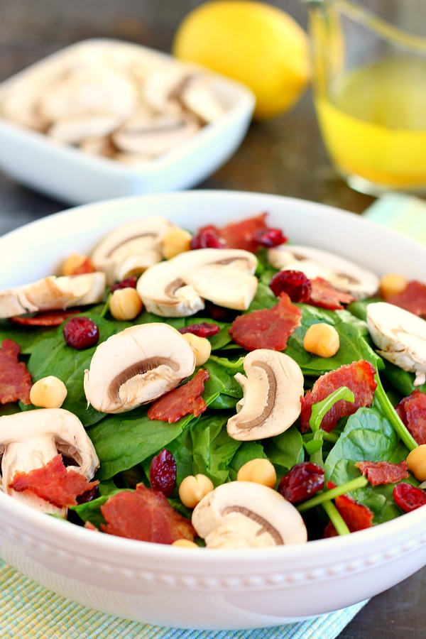 This Cranberry Mushroom Spinach Salad with Lemon Basil Vinaigrette combines baby spinach leaves, dried cranberries, fresh mushrooms, chickpeas, and crumbled bacon, all tossed with a lemon basil dressing. This dish is easy to throw together and serves as the perfect lunch or dinner!