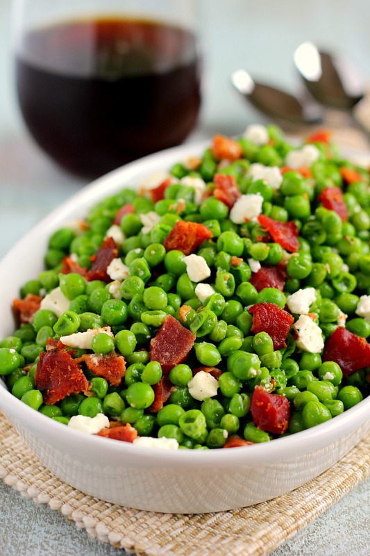 These Bacon and Feta Peas are seasoned with a buttery garlic sauce and packed with crumbled bacon and creamy feta cheese. It’s an easy side dish that takes just minutes to make and is sure to be a favorite in your household! #peas #pearecipe #baconpeas #vegetables #vegetablerecipe #sidedish #easysidedish