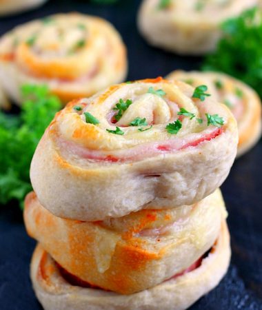 These Baked Ham and Cheese Roll-Ups contain just three ingredients and are ready in less than 20 minutes. Filled with deli ham, swiss cheese, and rolled up in a pre-made pizza dough, these roll-ups are sure to be the hit of the dinner table!