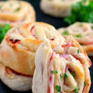 These Baked Ham and Cheese Roll-Ups contain just three ingredients and are ready in less than 20 minutes. Filled with deli ham, swiss cheese, and rolled up in a pre-made pizza dough, these roll-ups are sure to be the hit of the dinner table!