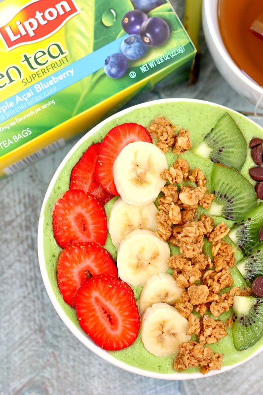 overhead view of a healthy green smoothie bowl with toppings next to a box of Lipton tea. 