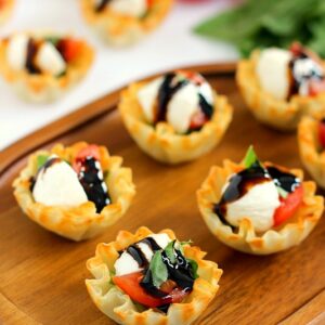 These Caprese Cups are a delicious bite-sized appetizer that will be the hit of your next party! Filled with cherry tomatoes, mozzarella cheese, fresh basil and a drizzle of balsamic glaze, these bites are easy to make and even better to eat!