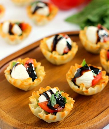 These Caprese Cups are a delicious bite-sized appetizer that will be the hit of your next party! Filled with cherry tomatoes, mozzarella cheese, fresh basil and a drizzle of balsamic glaze, these bites are easy to make and even better to eat!