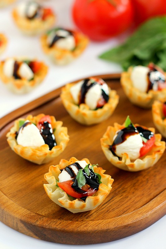 These Caprese Cups are a delicious bite-sized appetizer that will be the hit of your next party! Filled with cherry tomatoes, mozzarella cheese, fresh basil and a drizzle of balsamic glaze, these bites are easy to make and even better to eat!