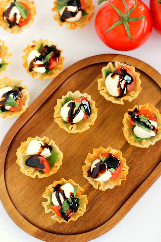 These Caprese Cups are a delicious bite-sized appetizer that will be the hit of your next party! Filled with cherry tomatoes, mozzarella cheese, fresh basil and a drizzle of balsamic glaze, these bites are easy to make and even better to eat!