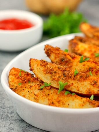 baked garlic parmesan potato wedges in a white bowl