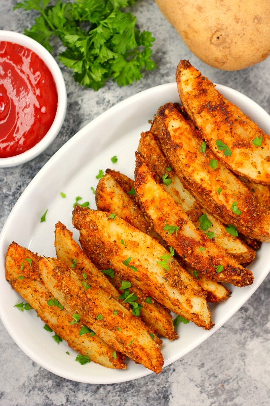 top down view of oven roasted potato wedges in a white bowl