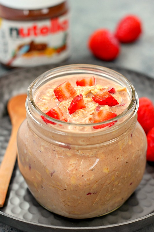 A glass jar of chocolate strawberry overnight oats, made with Nutella. 