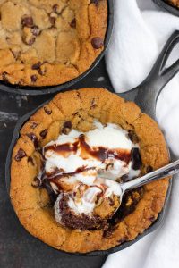 top down view of mini cast iron skillet cookie made with premade dough garnished with ice cream and a spoon