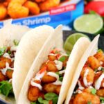 These Cilantro Lime Popcorn Shrimp Tacos are filled with crispy popcorn shrimp, a zesty cilantro lime sauce, and topped with a cilantro cream drizzle. Easy to make and ready in just 20 minutes, this flavorful dish will be the hit of your dinner table!