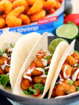 These Cilantro Lime Popcorn Shrimp Tacos are filled with crispy popcorn shrimp, a zesty cilantro lime sauce, and topped with a cilantro cream drizzle. Easy to make and ready in just 20 minutes, this flavorful dish will be the hit of your dinner table!