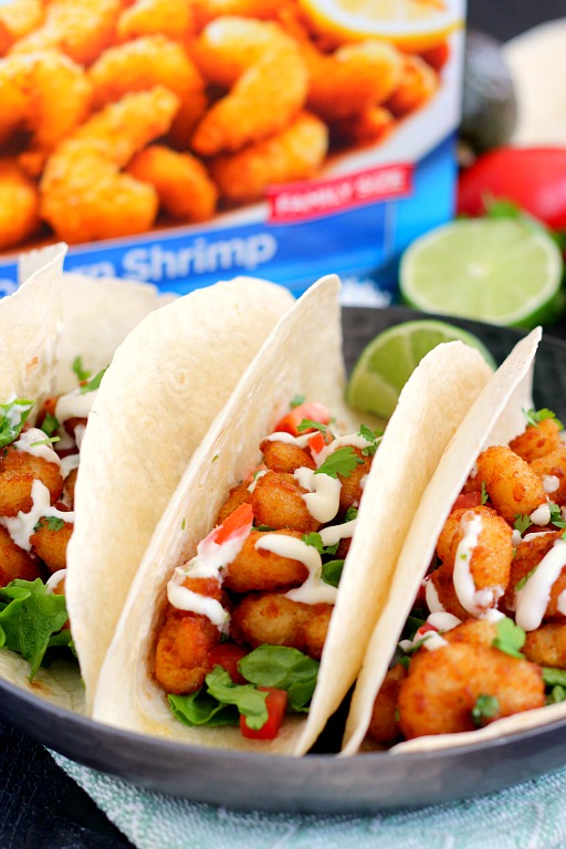 These Cilantro Lime Popcorn Shrimp Tacos are filled with crispy popcorn shrimp, a zesty cilantro lime sauce, and topped with a lime cream drizzle. Easy to make and ready in just 20 minutes, this flavorful dish will be the hit of your dinner table! #shrimp #popcornshrimp #tacos #shrimptacos #popcornshrimptacos #tacotuesday #seafood #seafoodtacos #easydinner