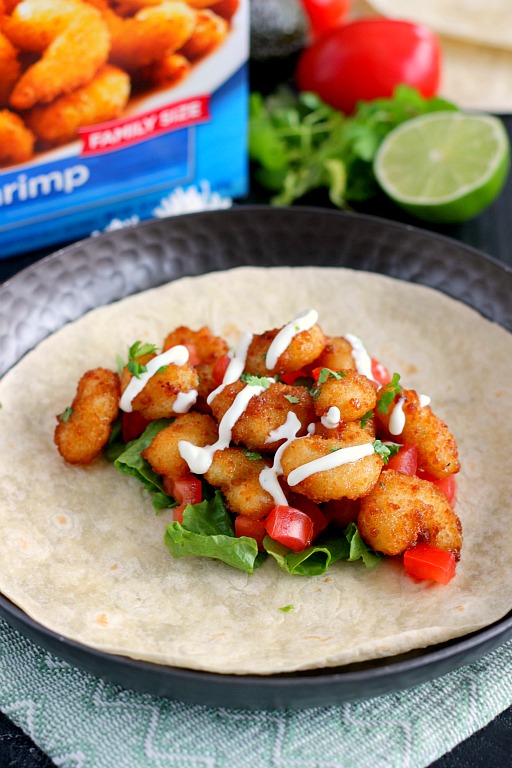 These Cilantro Lime Popcorn Shrimp Tacos are filled with crispy popcorn shrimp, a zesty cilantro lime sauce, and topped with a cilantro cream drizzle. Easy to make and ready in just 20 minutes, this flavorful dish will be the hit of your dinner table!