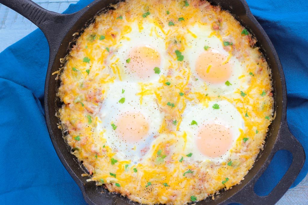 corned beef hash and eggs in a cast iron skillet, viewed from above